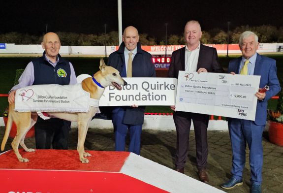 Pat Flanagan, Chairman of Greyhound Racing Ireland, hands over a cheque for €12,000 to Dan Quirke, the money was raised for the Dillon Quirke Foundation at greyhound stadia across Ireland in October 2025. They are accompanied by Tim Lucey, CEO of Greyhound Racing Ireland, and Chris Walsh and his greyhound Gold, represenating the Irish Retired Greyhound Trust. Image shows 4 men and a greyhound - the men are Chris Walsh with his retired Greyhound Gold, Tim Lucey CEO of Greyhound Racing Ireland, Dan Quirke of the Dillon Quirke Foundation, and Pat Flanagan Chairman of Rásaíocht Con Éireann, pictured with a large cheque to highlight the €12,000 raised for the Dillon Quirke Foundation