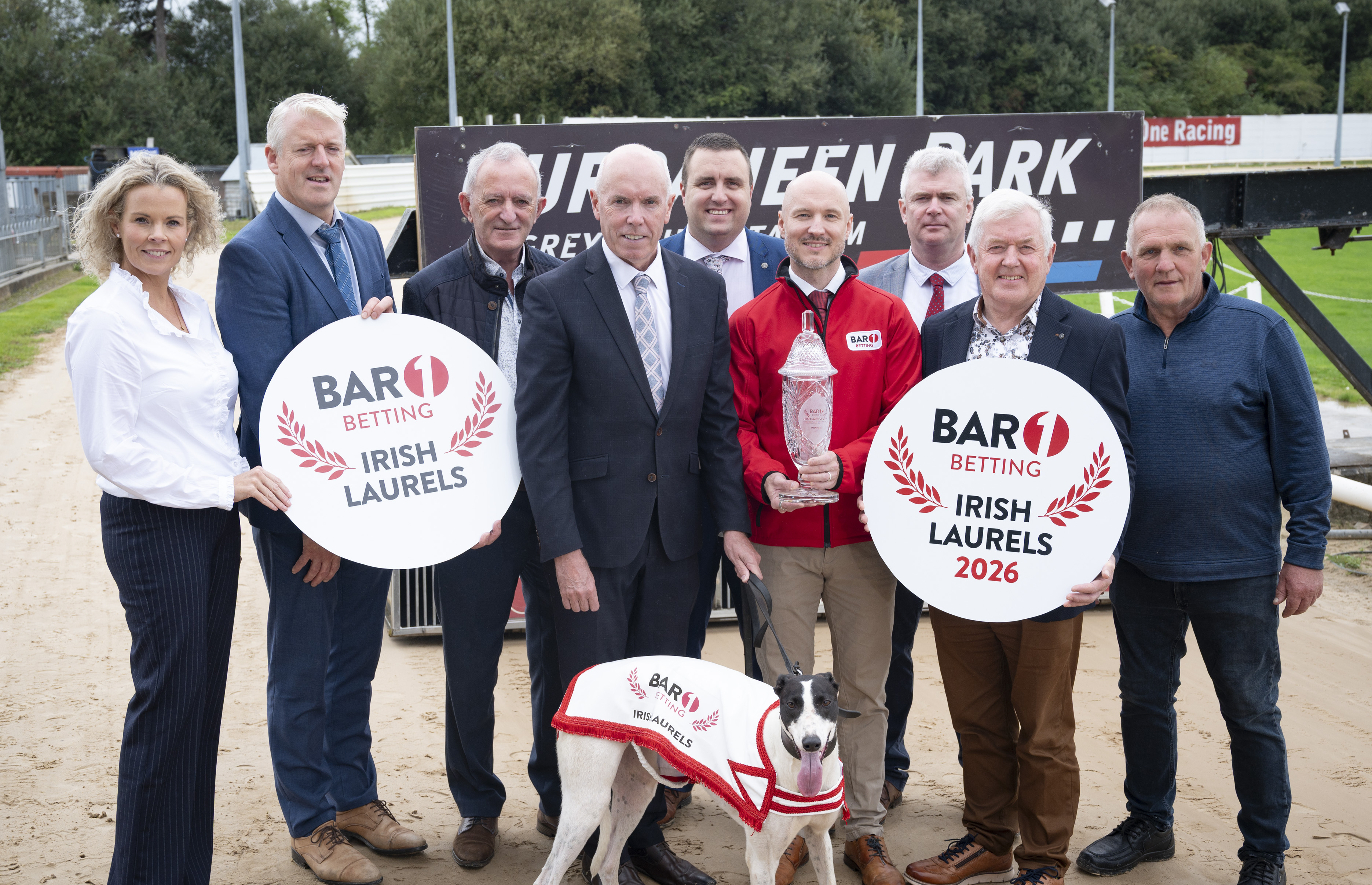 The 2026 Bar 1 Betting Irish Laurels gets underway on Saturday 26th September with the Final on Saturday 17th October in Cork's Curraheen Park Image shows a group of people standing on the sand track at Curraheen Park launching the 2026 BAR 1 Betting Irish Laurels