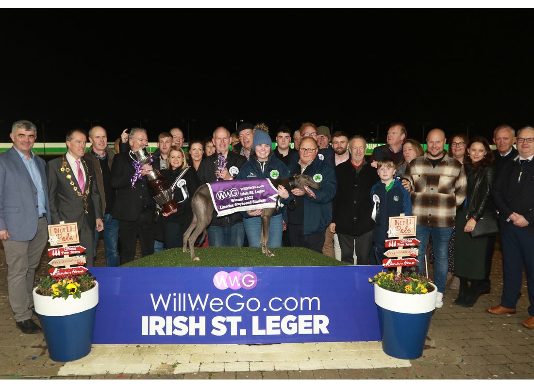 Image shows a large group of people at the winner's podium of Limerick Greyhound Stadium for the presentation by WillWeGo.com's Ray Quinn to winning owners James and Muireann Murphy, trainer Graham Holland, Breeder Jerry Murphy and winning greyhound Clonbrien Treaty. The group includes a number of people including the Mayor of Limerick and TD's and Councillors and connections of the 2023 WillWeGo.com Irish St Leger Final Image shows a large group of people at the winner's podium of Limerick Greyhound Stadium for the presentation by WillWeGo.com's Ray Quinn to winning owners James and Muireann Murphy, trainer Graham Holland, Breeder Jerry Murphy and winning greyhound Clonbrien Treaty. The group includes a number of people including the Mayor of Limerick and TD's and Councillors and connections of the 2023 WillWeGo.com Irish St Leger Final